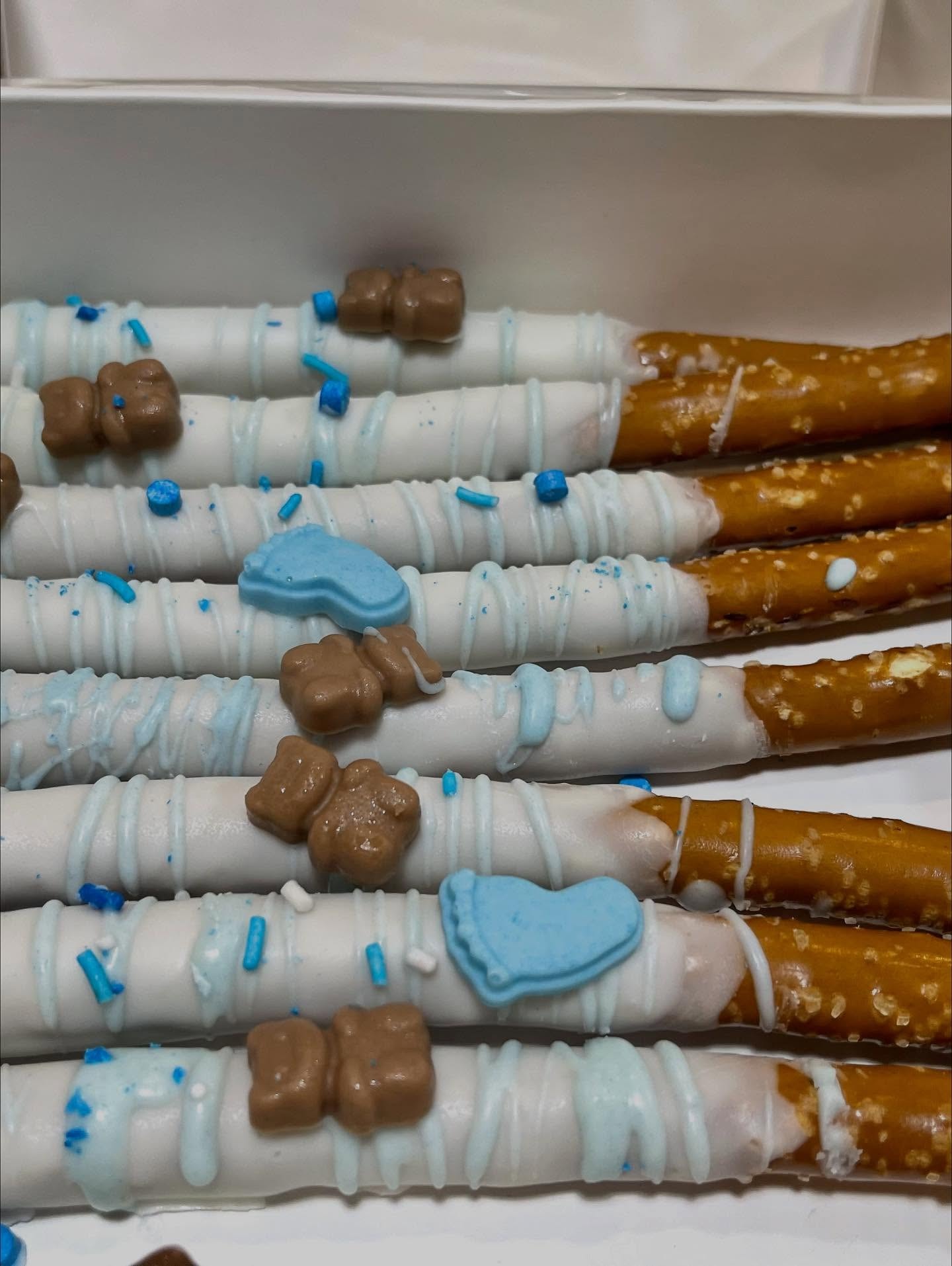 White chocolate pretzel rods with blue footprints and teddy bears