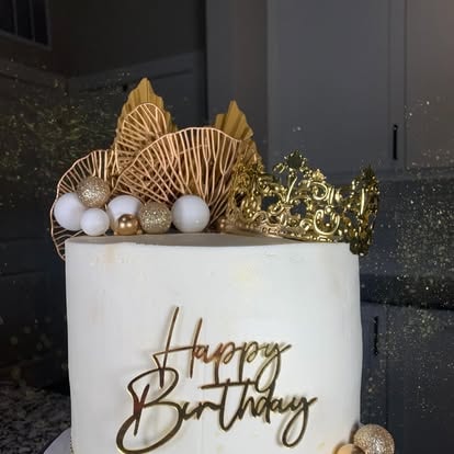 White birthday cake with gold crown and Happy Birthday topper