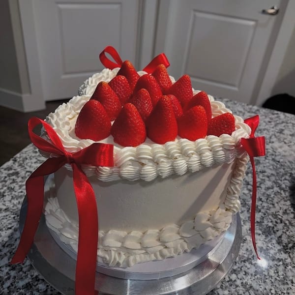 Strawberry cream cake with red ribbon bows