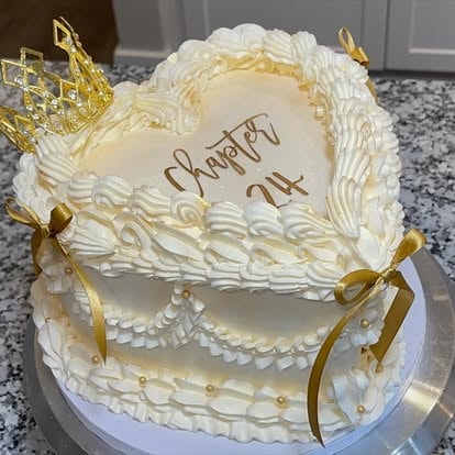 Gold heart shaped Chapter 24 birthday cake with crown topper