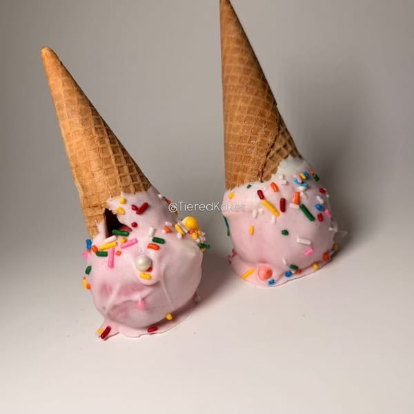 Pink ice cream cone cake pops with colorful sprinkles