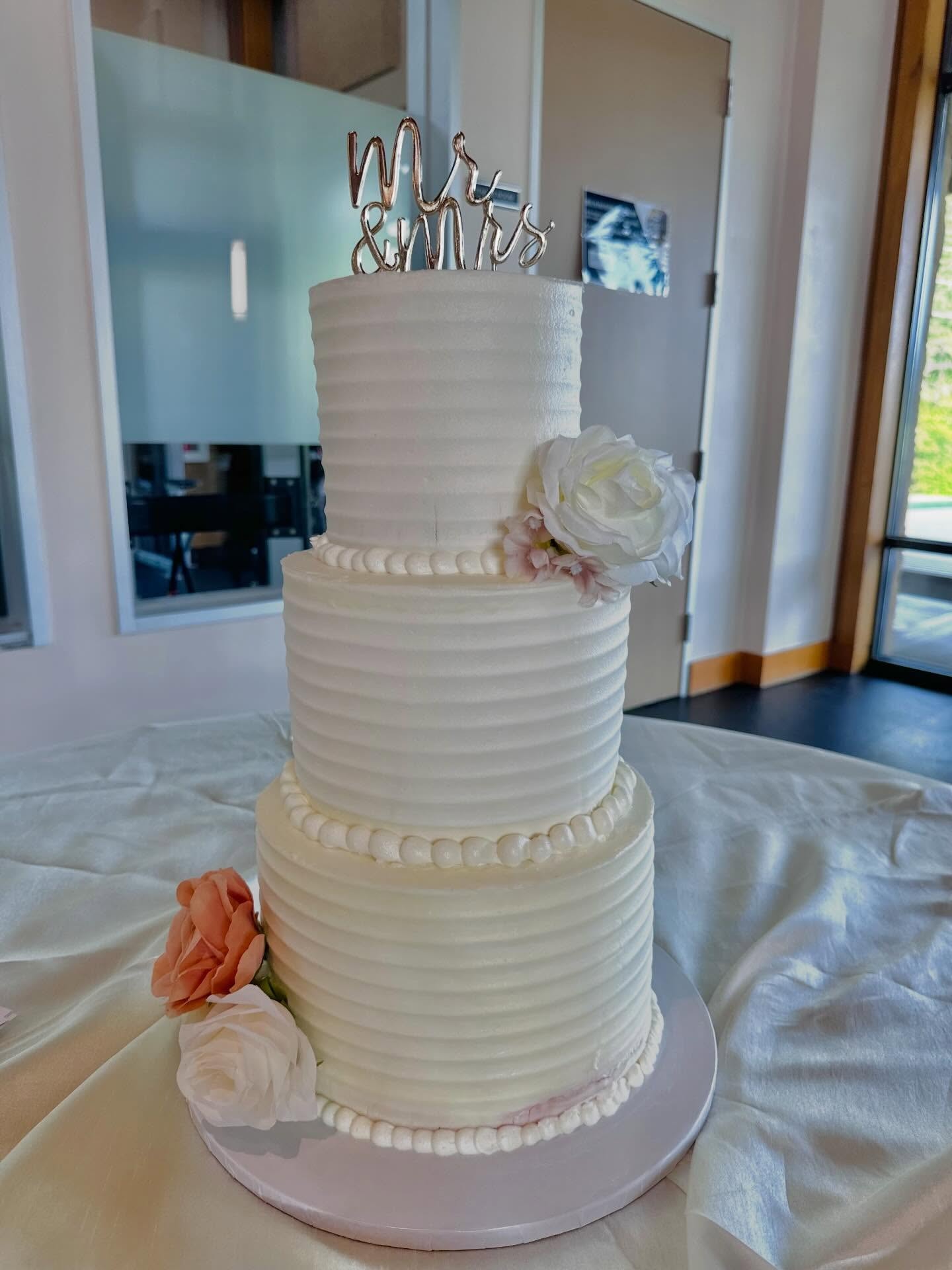 Three tier textured wedding cake with fresh flowers